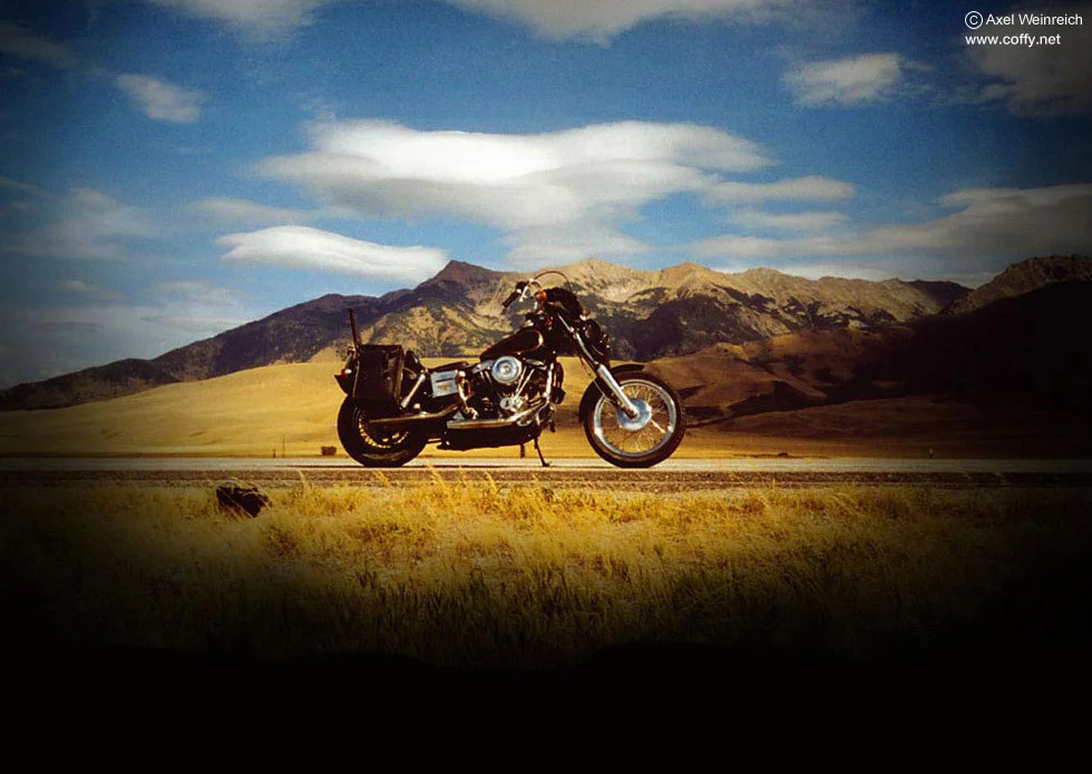 Motorcycle with grassy plains and mountains in the background