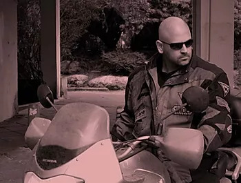 Black and white photo of man sitting on a motorcyle